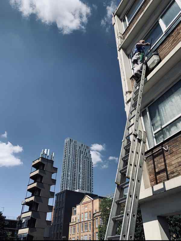 cleaning second floor window by hand
